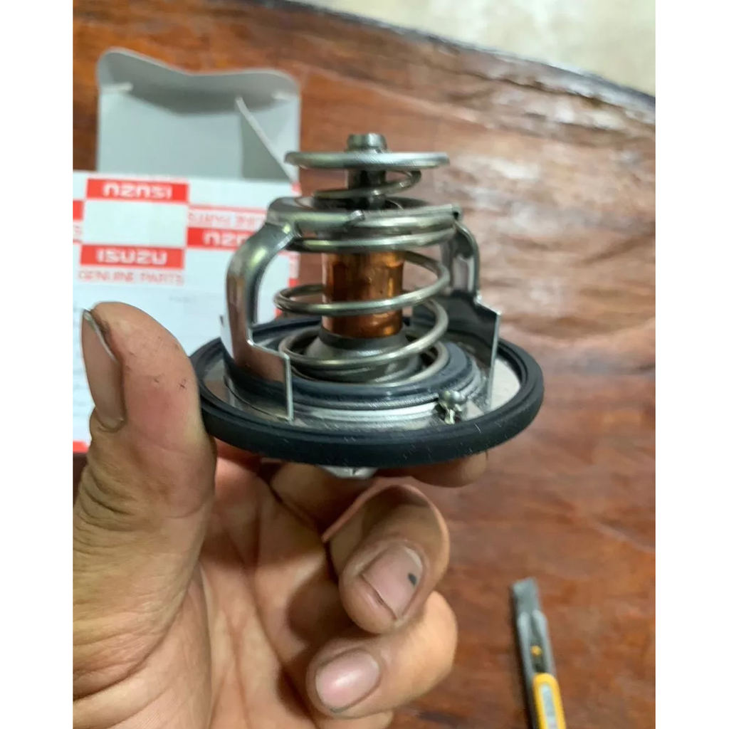 Close-up side view of Isuzu thermostat with spring assembly and black sealing ring