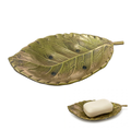 Underside of brass leaf soap dish showing drainage holes and silver-tone finish