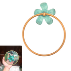 Brass flower towel ring close-up showing verdigris green patina detail on plumeria petals