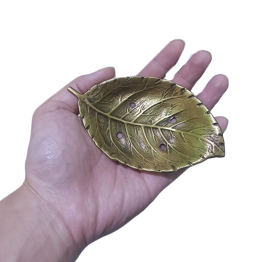 Brass leaf soap dish with white bar of soap placed on top, side view