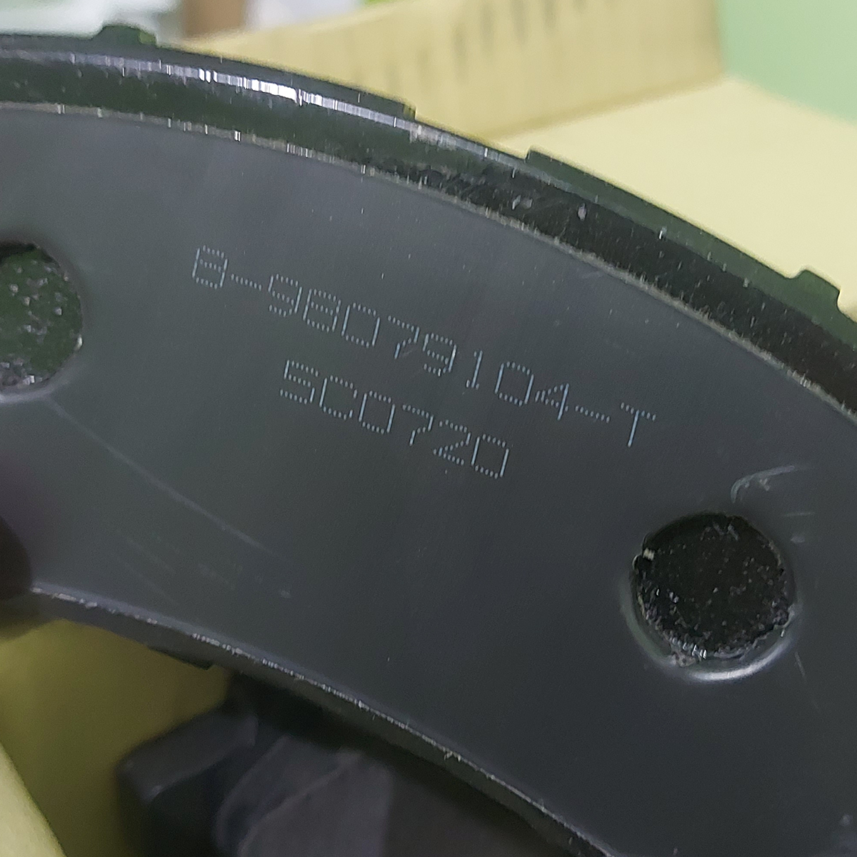 Close-up of brake pad part number marking