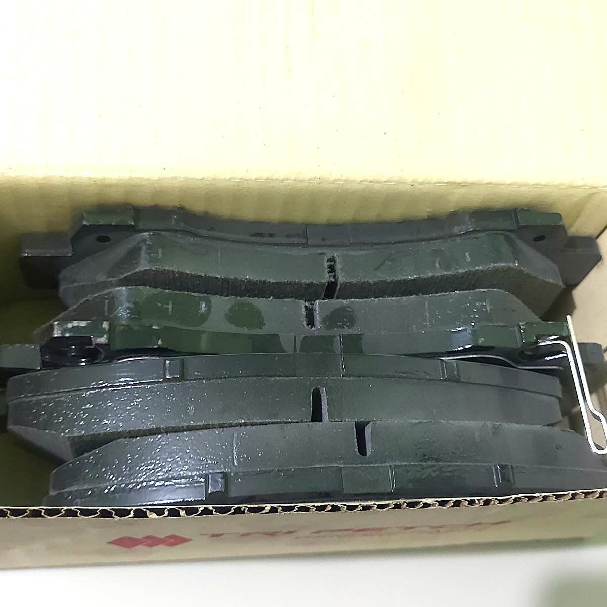 Isuzu front brake pads arranged inside packaging